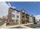 Exterior view of charming three-story apartment building with brick accents and inviting balconies at 10785 W 63Rd Pl # 202, Arvada, CO 80004