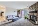 Comfortable living room with a stone fireplace, plush seating, and a sliding glass door at 10785 W 63Rd Pl # 202, Arvada, CO 80004