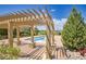 Community pool featuring a pergola, stone columns and lush landscaping with scenic views at 3437 Rosato Dr # C, Highlands Ranch, CO 80126