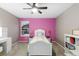 Bright bedroom with a pink wall, white furniture and a large window offering a view outside at 18233 E Dorado Ave, Centennial, CO 80015