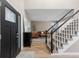 Inviting foyer showcasing staircase, neutral walls, light wood floors, and black accents at 18233 E Dorado Ave, Centennial, CO 80015