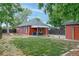 View of a backyard with a well manicured lawn and a red house and matching garage at 4841 Alcott St, Denver, CO 80221