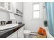 Well-lit bathroom with a stylish black and white tiled floor, white cabinets, and an inviting window at 4841 Alcott St, Denver, CO 80221