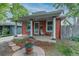 Charming home featuring a cozy front porch with decorative columns and a colorful garden display at 4841 Alcott St, Denver, CO 80221