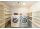 Functional laundry room with dual washers and dryers, complemented by ample shelving for organized storage at 4841 Alcott St, Denver, CO 80221
