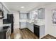 Modern kitchen featuring black appliances, light grey cabinets, and hardwood floors for a sleek design at 3833 S Bahama St, Aurora, CO 80013