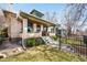 Side view of a home with a well-manicured lawn, black iron fence, and inviting front porch with space for relaxing at 438 S Emerson St, Denver, CO 80209