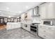 Open concept kitchen with white cabinets, hexagon tile floors, stainless steel appliances and an island with seating at 438 S Emerson St, Denver, CO 80209