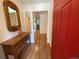 Inviting entryway featuring hardwood floors, a decorative mirror, and a bold red door at 540 S Forest St # A2, Denver, CO 80246