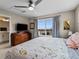 Spacious bedroom with a ceiling fan, dresser, and large windows providing natural light and neighborhood views at 6162 W 28Th Ct, Edgewater, CO 80214