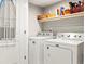Practical laundry room equipped with a washer, dryer, and shelving for organized storage and convenience at 6162 W 28Th Ct, Edgewater, CO 80214