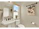 Charming powder room features a pedestal sink, a decorative mirror and a bright window at 3720 Pecos Trl, Castle Rock, CO 80109