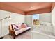 Cozy Bedroom room with a futon couch, crib and a brightly painted orange ceiling at 3720 Pecos Trl, Castle Rock, CO 80109