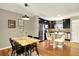 Modern dining room with stylish lighting, seating for six, and stainless steel appliances in the kitchen at 3720 Pecos Trl, Castle Rock, CO 80109