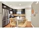 Modern kitchen features stainless steel appliances, dark cabinets, and a central island with granite countertop and seating at 3720 Pecos Trl, Castle Rock, CO 80109