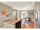 Open concept kitchen with island, stainless steel refrigerator, and view to dining area and entry at 3720 Pecos Trl, Castle Rock, CO 80109