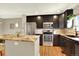 Bright kitchen boasts stainless appliances, granite counters, dark cabinetry, and a central island, perfect for cooking at 3720 Pecos Trl, Castle Rock, CO 80109