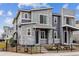 Modern townhome featuring stone accents, gray siding, a covered entryway, and black iron fence at 4588 S Versailles St # A, Aurora, CO 80015