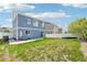 View of a home's spacious backyard with grassy area, white fence, and a concrete patio at 5571 Killarney St, Denver, CO 80249