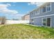 Spacious backyard featuring a white fence, grassy area, and a concrete patio at 5571 Killarney St, Denver, CO 80249