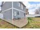 View of the backyard featuring a blue house and a wet concrete patio at 5571 Killarney St, Denver, CO 80249