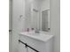Updated bathroom featuring white vanity, modern fixtures, and a large mirror at 5571 Killarney St, Denver, CO 80249
