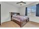 Comfortable bedroom with plush bedding, a ceiling fan, and a window with privacy blinds at 5571 Killarney St, Denver, CO 80249