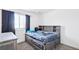 Bedroom with nice headboard with shelves, drawers under bed, and window with curtains at 5571 Killarney St, Denver, CO 80249