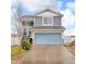 Two-story home features gray siding, blue garage door, and manicured front yard at 5571 Killarney St, Denver, CO 80249