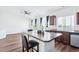 Bright kitchen featuring wood floors, a large island with seating, and stainless steel appliances at 5571 Killarney St, Denver, CO 80249