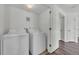 Laundry room with full sized washer and dryer and wood floor at 5571 Killarney St, Denver, CO 80249