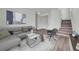 Bright living room features contemporary decor, wood floors, and staircase access at 5571 Killarney St, Denver, CO 80249