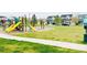 Community playground with slides and swings surrounded by green lawn and neighboring houses at 5571 Killarney St, Denver, CO 80249