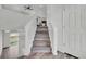 Stairway featuring hardwood steps, white risers and handrail, connecting to a bright open space at 5571 Killarney St, Denver, CO 80249