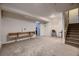 Spacious basement featuring carpeted floors, shelving, and a staircase to the upper level at 2697 S Deframe Cir, Lakewood, CO 80228
