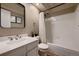 Cozy bathroom featuring white tiles in the shower, and a large mirror above the sink at 2697 S Deframe Cir, Lakewood, CO 80228