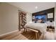 Bedroom with a cozy bed, dark accent wall, natural lighting and hardwood floors at 2697 S Deframe Cir, Lakewood, CO 80228