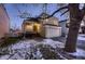 Evening view of charming two-story home with attached garage and snowy front yard at 2697 S Deframe Cir, Lakewood, CO 80228