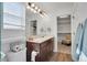 Bright bathroom with double vanity and dark wood cabinets, plus a view to the walk-in closet at 17838 E 54 Th Ave, Denver, CO 80249