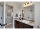Comfortable bathroom with dark brown cabinets, neutral countertop, bright mirror, and convenient access to the stairway at 17838 E 54 Th Ave, Denver, CO 80249