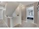 Hallway with carpeted floor and view of a bedroom with carpet, ceiling fan, and large windows at 17838 E 54 Th Ave, Denver, CO 80249