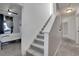 Bright hallway featuring carpeted stairs and view of a bedroom with a ceiling fan at 17838 E 54 Th Ave, Denver, CO 80249