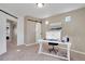 Bright home office with carpet, neutral walls, white desk, and sliding barn door to the left of the workspace at 17838 E 54 Th Ave, Denver, CO 80249