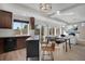 Open concept kitchen and dining room feature dark wood cabinets, a movable island, and ample natural light at 17838 E 54 Th Ave, Denver, CO 80249