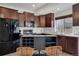 Modern kitchen boasts espresso cabinets, black appliances, and a portable island with a beverage rack at 17838 E 54 Th Ave, Denver, CO 80249