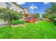 Green backyard featuring a spacious lawn, a garden bed, a covered deck and a fence at 2316 Weatherstone Cir, Highlands Ranch, CO 80126