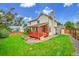 Backyard view with lush green lawn, trees, a deck and access to outdoor shed at 2316 Weatherstone Cir, Highlands Ranch, CO 80126