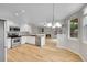 Bright kitchen featuring stainless steel appliances, white cabinets, and hardwood floors overlooking the living area with a fireplace at 2316 Weatherstone Cir, Highlands Ranch, CO 80126
