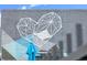 Brick wall with a geometric heart mural and a corner of a blue umbrella, creating a modern urban design at 3055 N York St, Denver, CO 80205