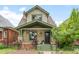 Charming two-story home with peaked roof, covered front porch, and lovely landscaping at 3055 N York St, Denver, CO 80205